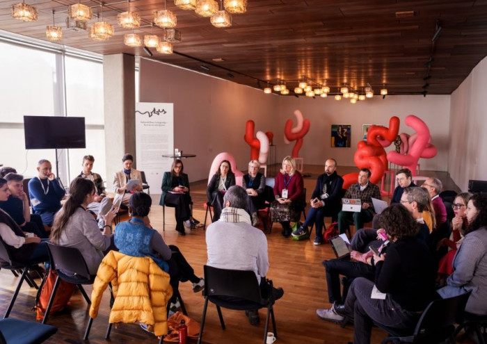 People sitting in a circle inside a room. 