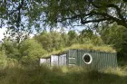 A small building in a forest environment. 