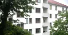 A multi-story white building with some trees. 