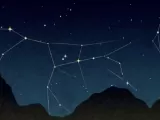 Stars linked with lines and an outline of a dark mountain. 