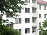 A multi-story white building with some trees. 