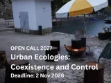 Text of the call on an image of an outdoor setting, paved and next to a boathouse. 