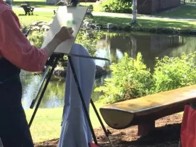 A person painting outside. 